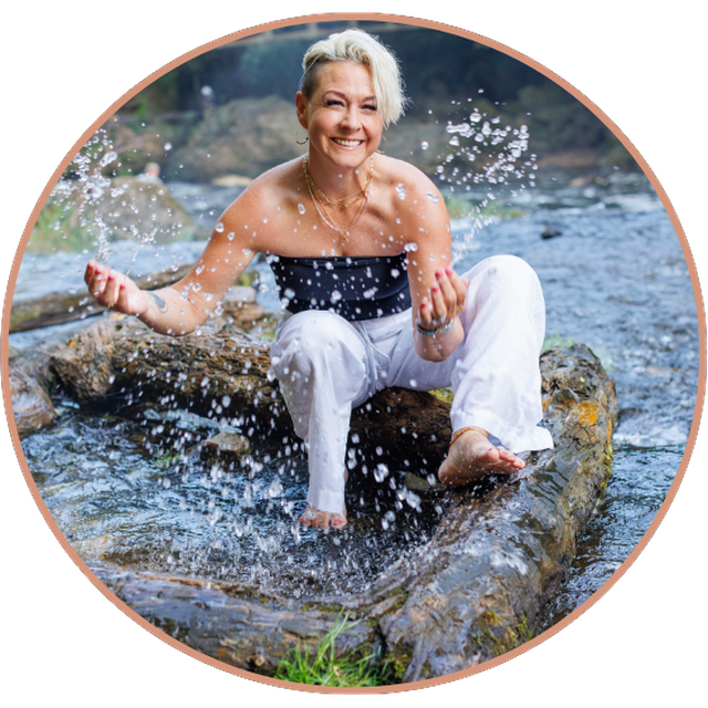 Lori laughing in a river, splashing water